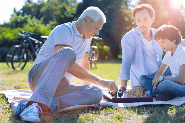 Abuelo consciente jugando ajedrez con su nieto
 - Foto, imagen