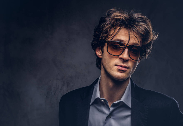 Retrato de estudio de un macho sensual carismático con pelo elegante y gafas de sol
 - Foto, imagen