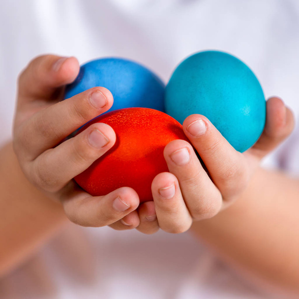 Paskalya. Boyalı yumurta bir çocuğun elinde. Fotoğraf portre - Fotoğraf, Görsel
