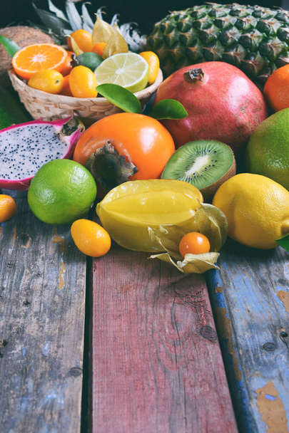 Mix of ripe tropical fruits with avocado mango, kumquat, kiwi, citrus. Superfood background. Vegetarian raw food. Copy space - Photo, Image