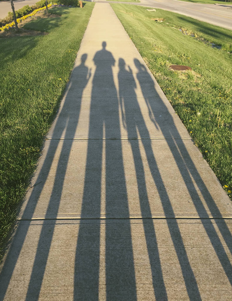 ein Schatten einer Familie, die spazieren geht.  - Foto, Bild