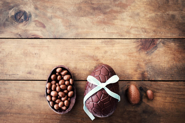  Beautiful creative photo with Chocolate Easter eggs on wooden background - 写真・画像