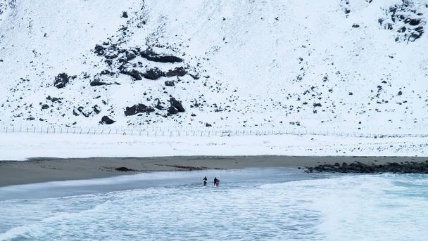 Surffaajat jäätävän kylmällä Lofoten Islandilla talvella, Norja
 - Valokuva, kuva