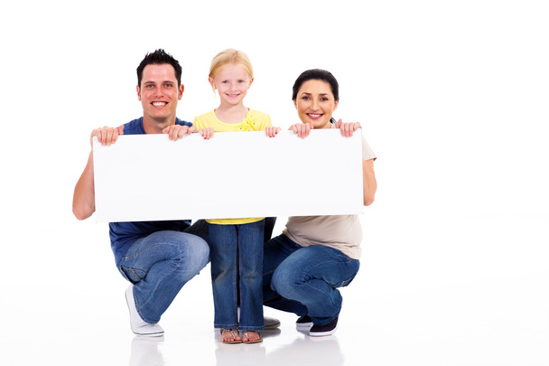 Young family with white banner isolated on white - Fotoğraf, Görsel