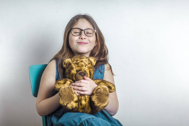 Щаслива маленька дівчинка обіймає іграшку, плюшевий ведмідь
. - Фото, зображення