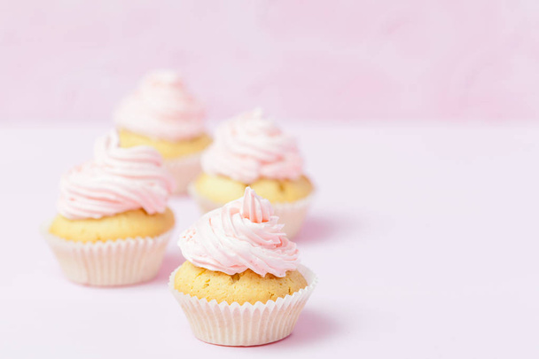 Cupcake decorated with pink buttercream on pastel pink background. Sweet beautiful cake. Horizontal banner, greeting card for birthday, wedding, women's day. Close up photography. Selective focus - Fotoğraf, Görsel