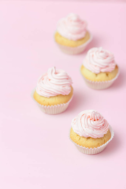 Cupcake ozdobione różowy lukier na pastelowy różowy tło. Słodkie piękny tort. Pionowy baner, z życzeniami na urodziny, ślub, dzień kobiet. Zamknij się fotografią. Selektywny fokus - Zdjęcie, obraz