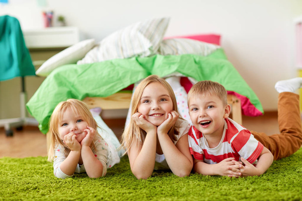 heureux petits enfants couchés sur le sol ou tapis
 - Photo, image