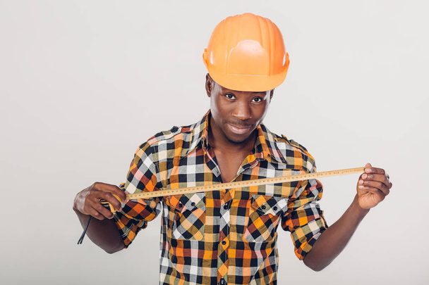 Афро-американських будівельник використовує вимірювальна стрічка - Фото, зображення