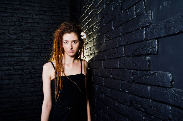 Studio shoot of girl in black with dreads on brick background. - Fotografie, Obrázek