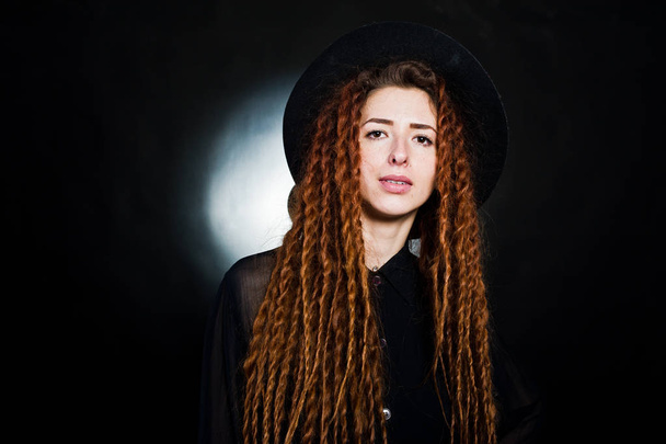Studio shoot of girl in black with dreads and hat at black backg - Фото, зображення