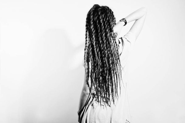 Studio shoot back of girl in gray dress with dreads on white bac - Photo, image