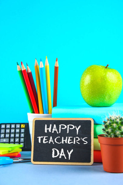 Text chalk on a chalkboard: Happy Teacher's Day. School supplies, office, books, apple. - Valokuva, kuva