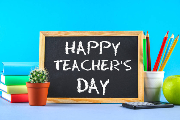 Text chalk on a chalkboard: Happy Teacher's Day. School supplies, office, books, apple. - Foto, afbeelding