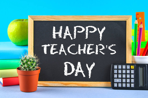 Text chalk on a chalkboard: Happy Teacher's Day. School supplies, office, books, apple. - Foto, afbeelding