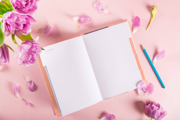Cuaderno abierto para escribir sueños e ideas con flores cerca
 - Foto, imagen