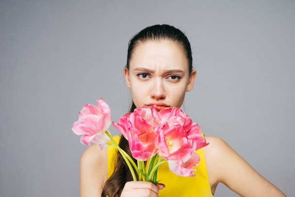 angry woman holding a bouquet of tulips in hands, March 8 - Fotoğraf, Görsel