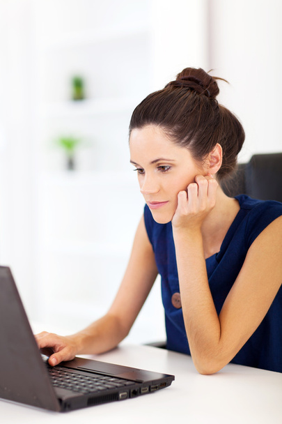 Thoughtful young woman sitting in front of laptop - Photo, Image