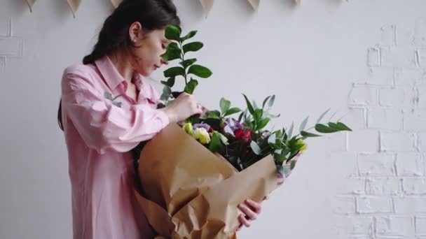 Florist inserts a branch of greenery in a large modern bouquet - Záběry, video