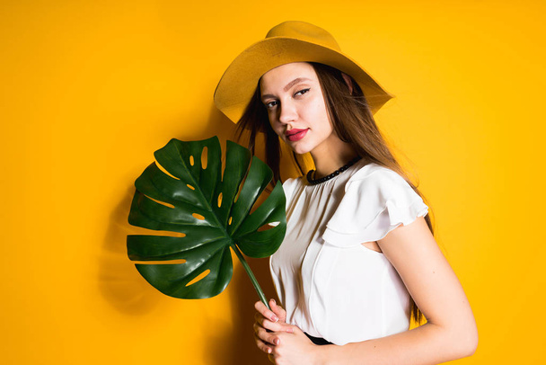 beautiful woman in a hat on a yellow background - Foto, Imagem
