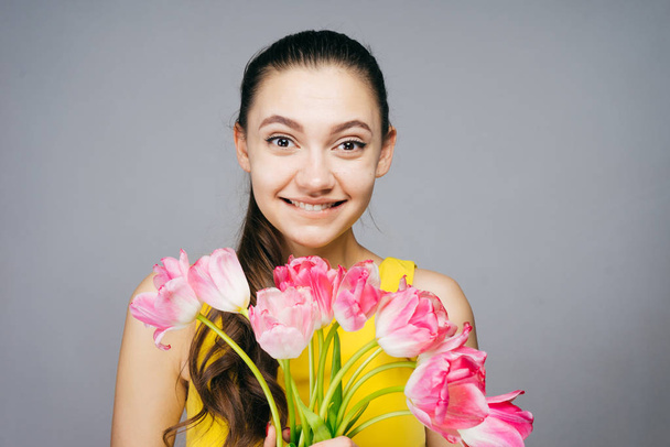 happy woman holding a bouquet of tulips in her hands, on March 8, women's day - Fotoğraf, Görsel