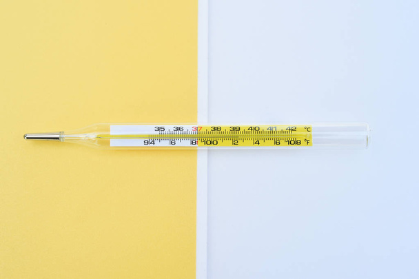 medical thermometer on yellow and white background - Photo, Image