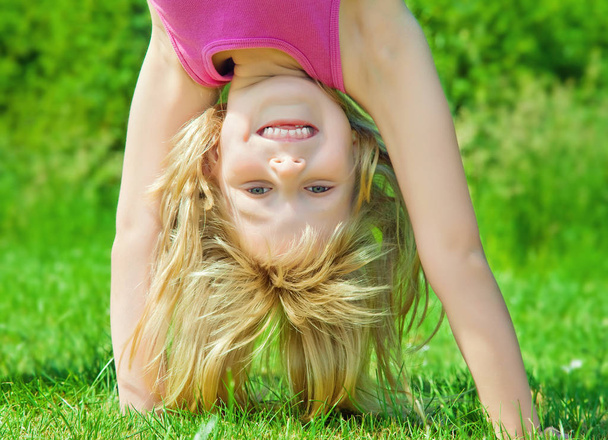 child stands upside down - Фото, зображення