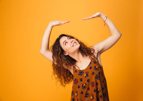 Portrait of a pretty curly haired girl holding copyspace - Foto, imagen