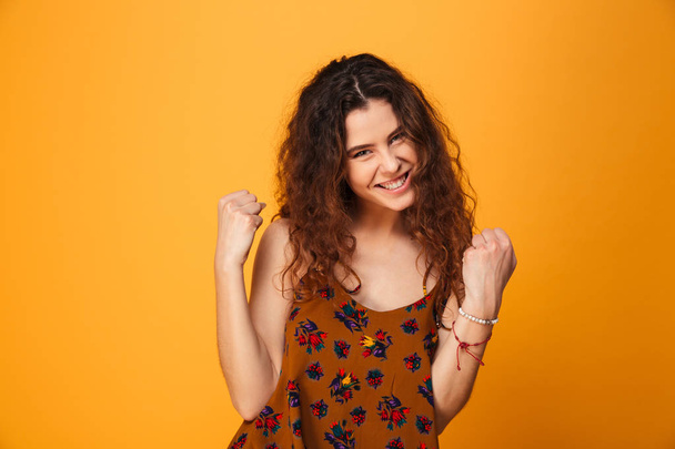 Portrait of a satisfied curly haired girl celebrating success - Foto, Imagen