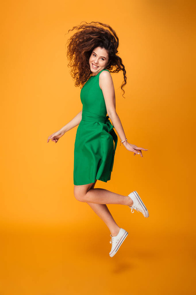 Full length portrait of a cheerful curly haired girl - Foto, afbeelding