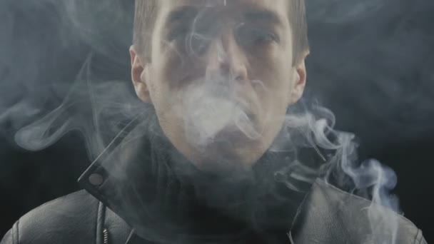 közeli kép a fiatal férfi dohányzik cigaretta-on fekete háttér - Felvétel, videó
