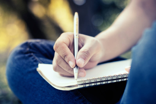 genç kadın yazma not defterinde park, edu kavramında kapatın - Fotoğraf, Görsel