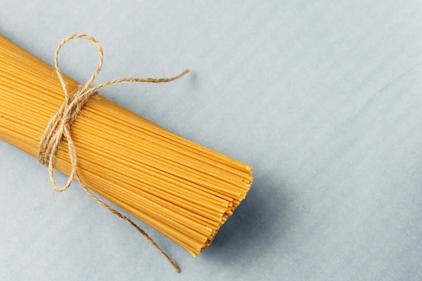 Uncooked pasta spaghetti on a blue background - Fotó, kép