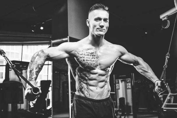 Brutal Caucasian bodybuilder training chest in gym - Photo, image