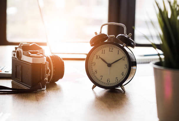 alarm clock and camera on working table in vintage styl - Φωτογραφία, εικόνα
