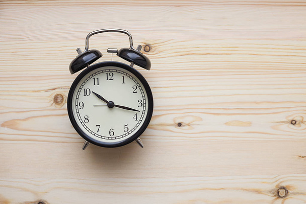 alarm clock on a wooden background - Foto, imagen