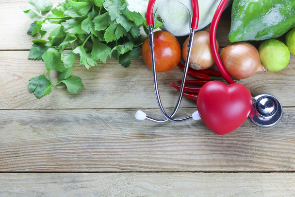 Concepto de hogar saludable, verduras y frutas con hoja de hierba y oreja médico sobre fondo de madera
 - Foto, Imagen