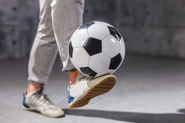 Man holds a soccer ball on his leg - Foto, Imagem