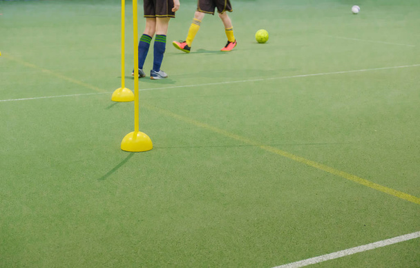 Soccer camp for kids. Children training soccer skills with balls and cones. Soccer slalom drills to improve football dribbling fast - 写真・画像