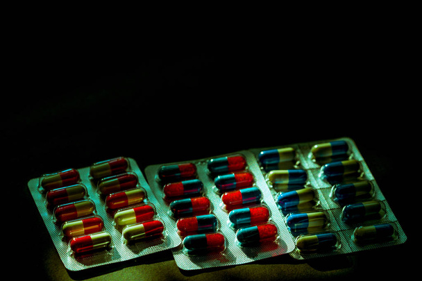 Colorido de píldoras de la cápsula antibiótica en blister en bac oscuro
 - Foto, Imagen