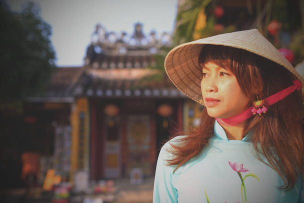 Vietnamees meisje jurken en traditionele hoeden in de oude stad van Hoi een. - Foto, afbeelding