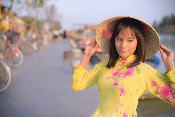 Robes de fille vietnamienne et chapeaux traditionnels dans la vieille ville de Hoi An
. - Photo, image