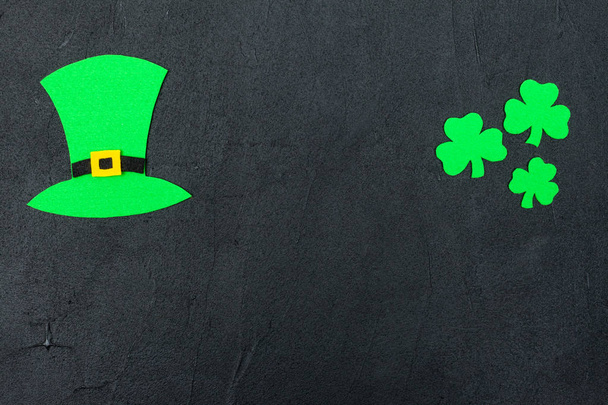 Tema St. Patrick 's Day banner horizontal colorido. Sombrero de duende verde y hojas de trébol sobre fondo negro. Elementos artesanales. Copiar espacio. Para la tarjeta de felicitación, banner de felicitación
 - Foto, imagen