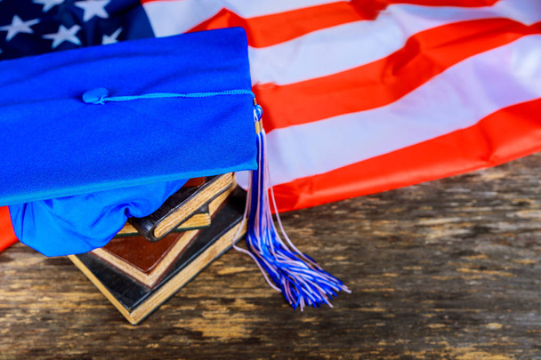 Kitaplar ile Amerikan bayrağı arka plan mavi mezuniyet şapka - Fotoğraf, Görsel