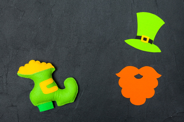 St. Patrick's Day theme colorful horizontal banner. Green leprechaun hat, beard and shoe with gold on black background. Felt craft elements. Copy space. For greeting card, congratulation banner - 写真・画像