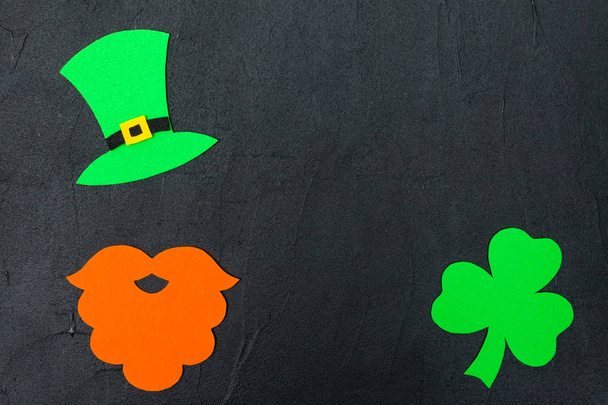 Tema St. Patrick 's Day banner horizontal colorido. Sombrero de duende verde, barba y hojas de trébol sobre fondo negro. Elementos artesanales. Copiar espacio. Para la tarjeta de felicitación, banner de felicitación
 - Foto, imagen