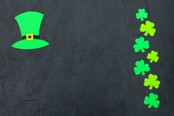 Tema St. Patrick 's Day banner horizontal colorido. Sombrero de duende verde y hojas de trébol sobre fondo negro. Elementos artesanales. Copiar espacio. Para la tarjeta de felicitación, banner de felicitación
 - Foto, Imagen