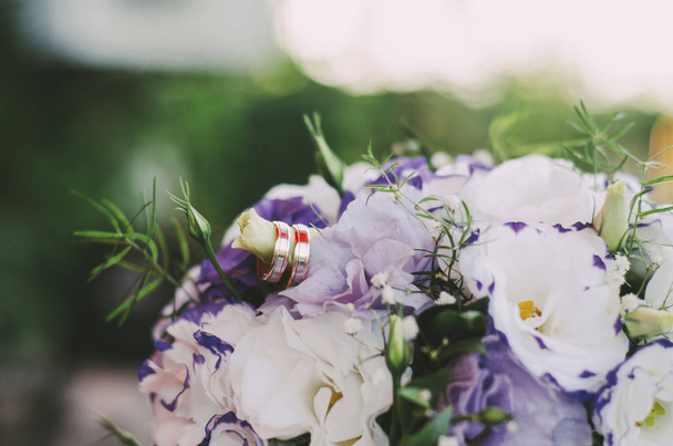 свадебный букет цветов с двумя золотыми кольцами на цветке
 - Фото, изображение