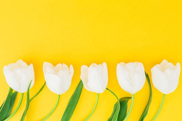 Composizione floreale con tulipani su fondo giallo. Posa piatta, vista dall'alto
 - Foto, immagini