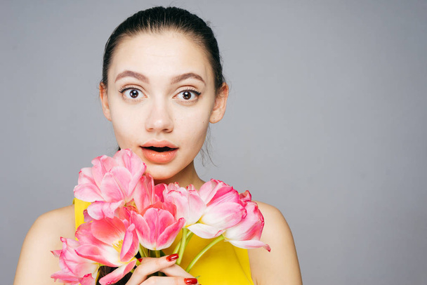 the amazed woman holding a bouquet of flowers in her hands, on March 8 - 写真・画像